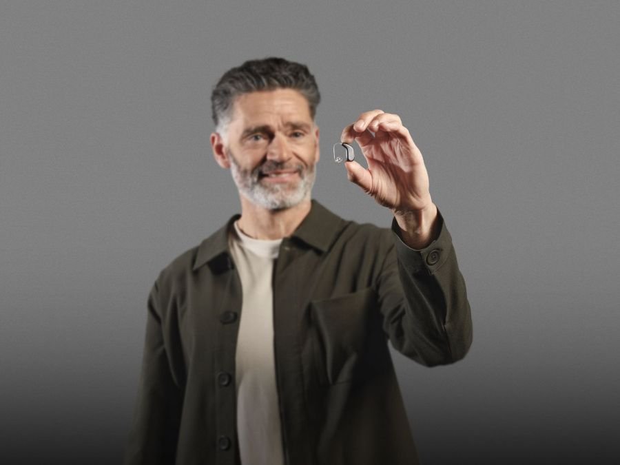 Homme présentant une aide auditive